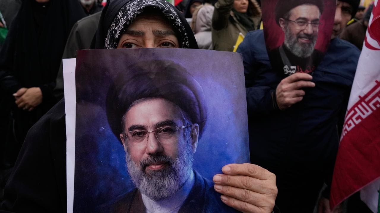 Demonstrators hold posters of Iran's supreme leader in Tehran
