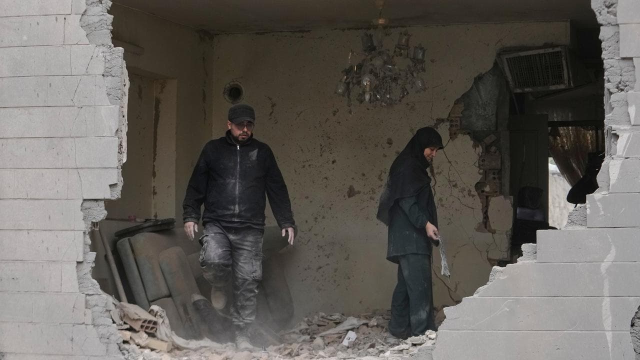People clean debris from their apartment in Tehran,