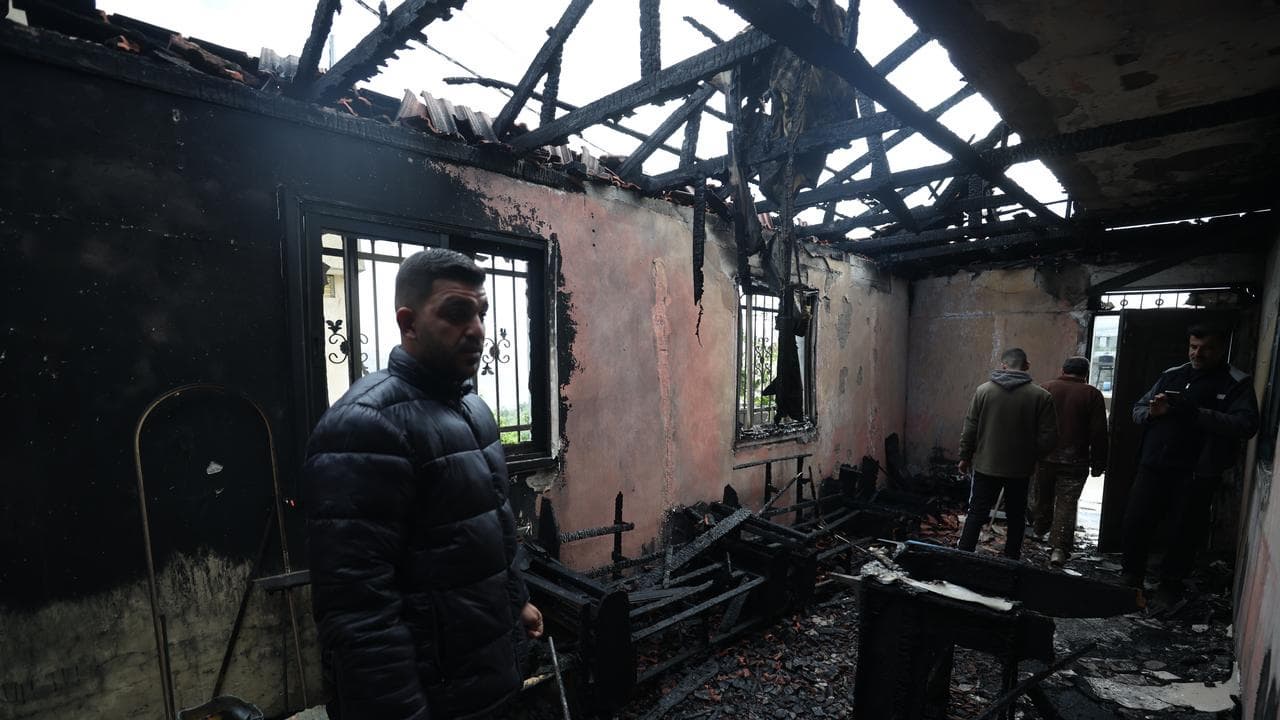 A man inspects a burnt out house