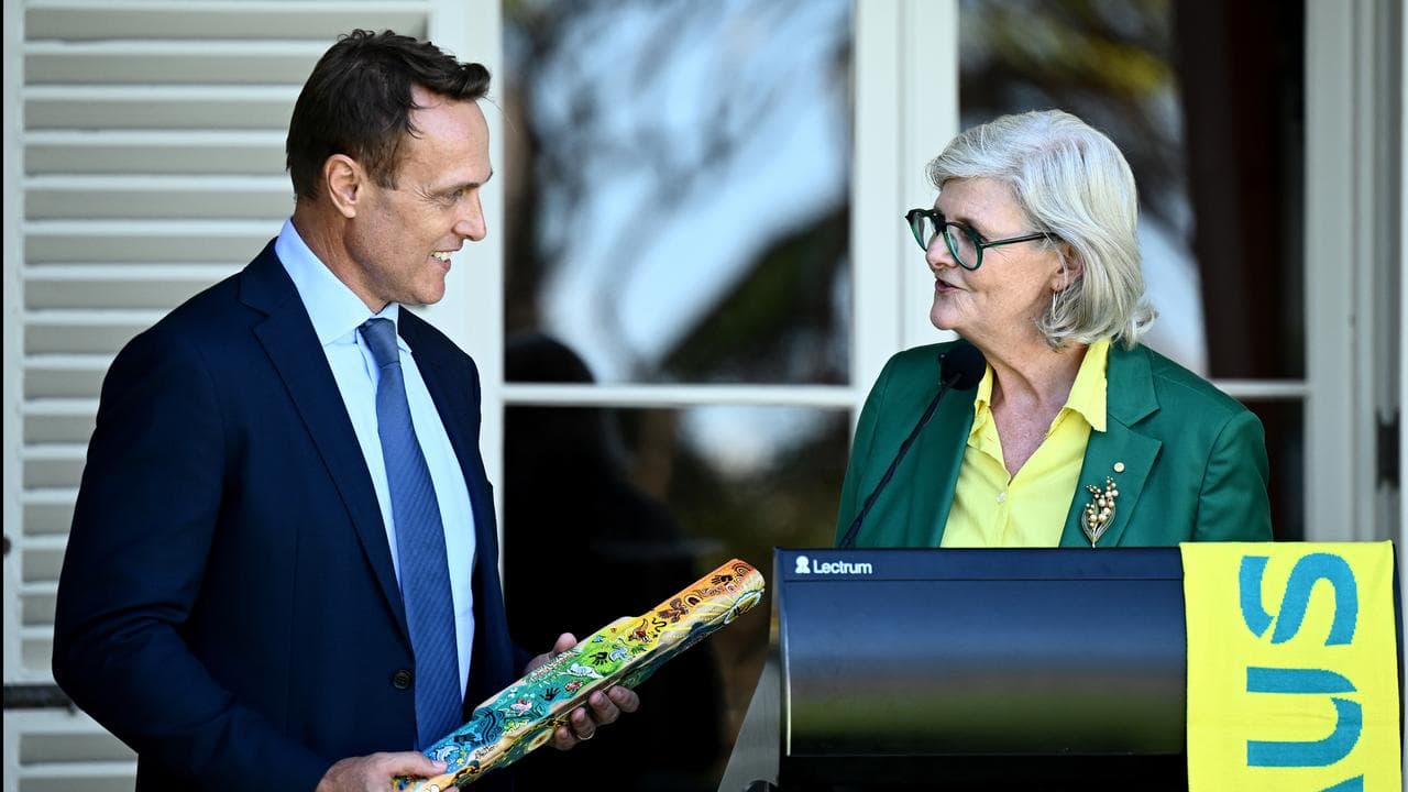 Matt Shirvington presents the baton to Governor General Sam Mostyn.