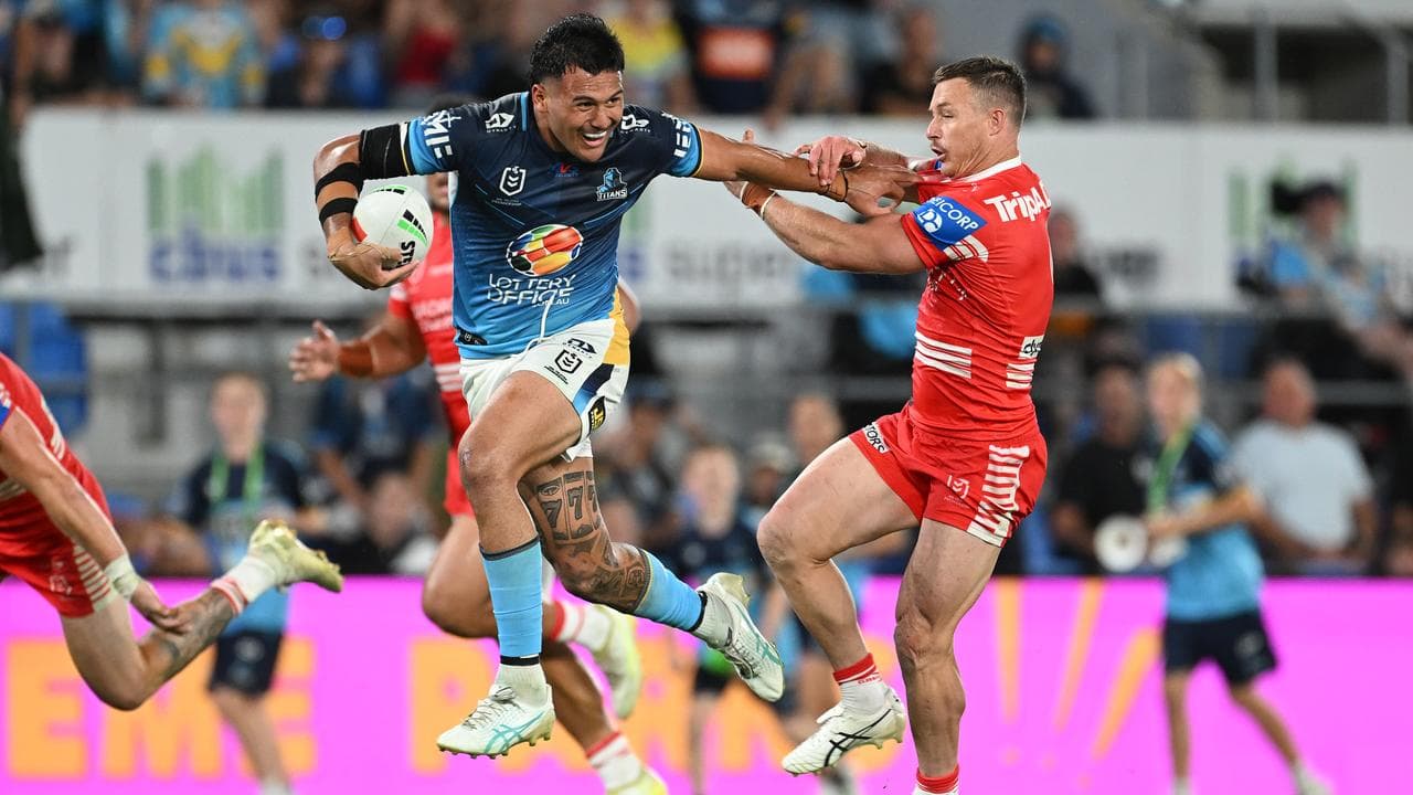 Arama Hau fends off the Dragons' Damien Cook