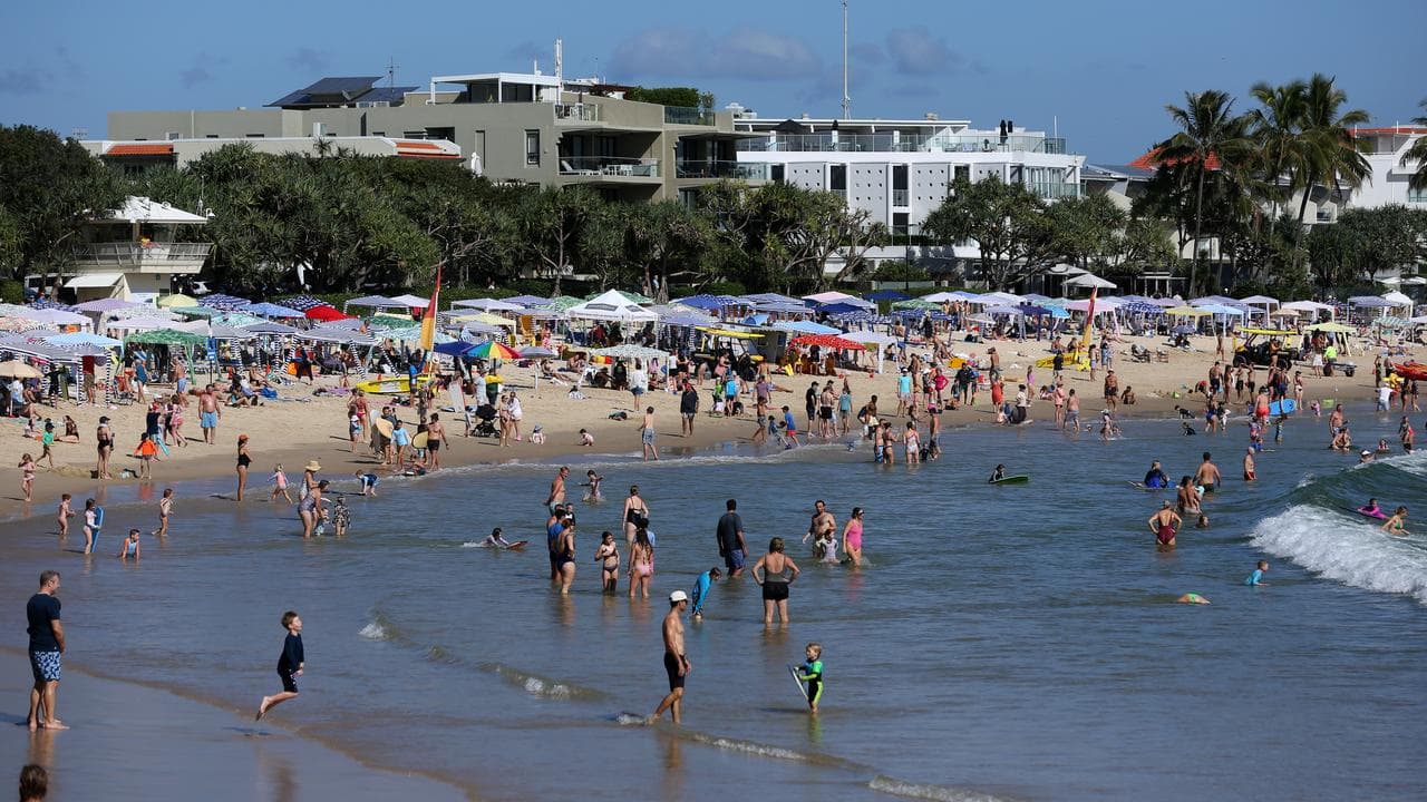 Beachgoers are seen at Noosa Main Beach