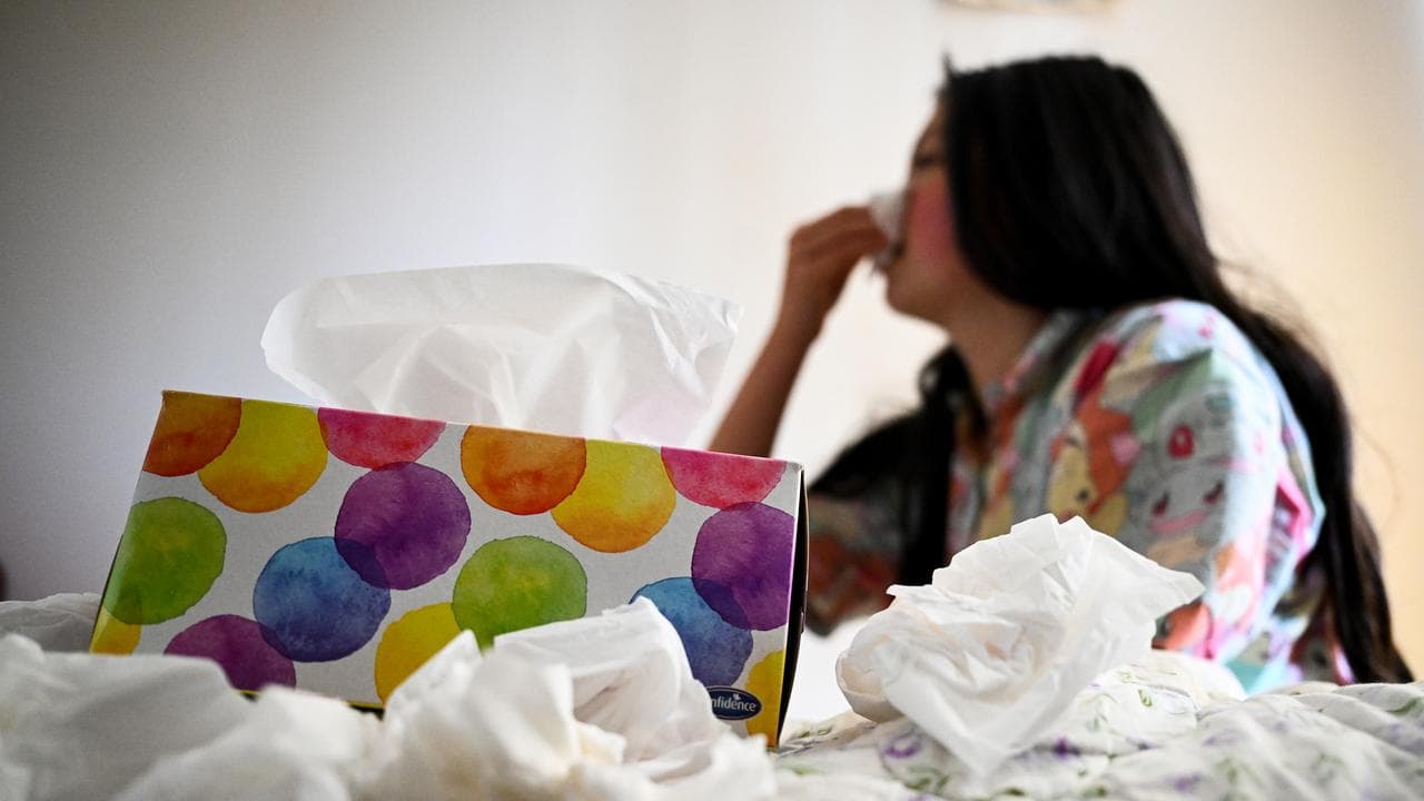 A young woman uses tissues (file image)