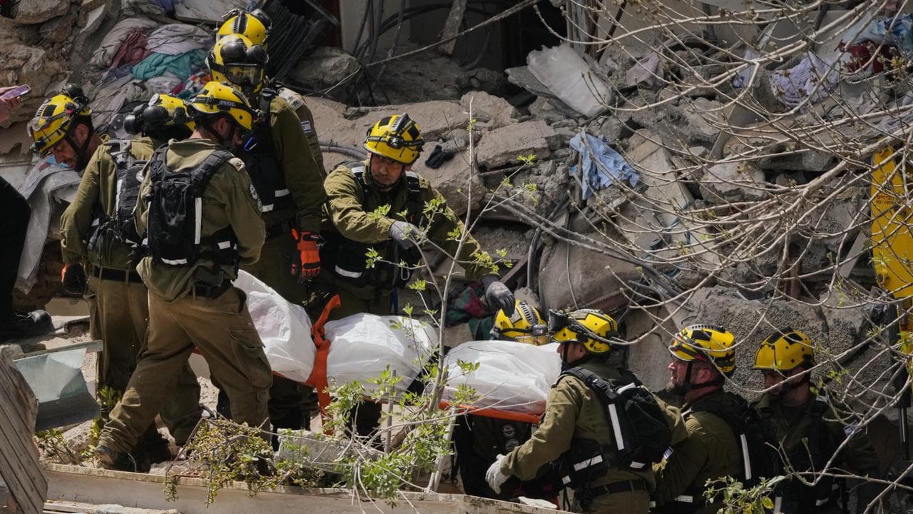 A body is carried from the site of an Iranian strike in Haifa, Israel