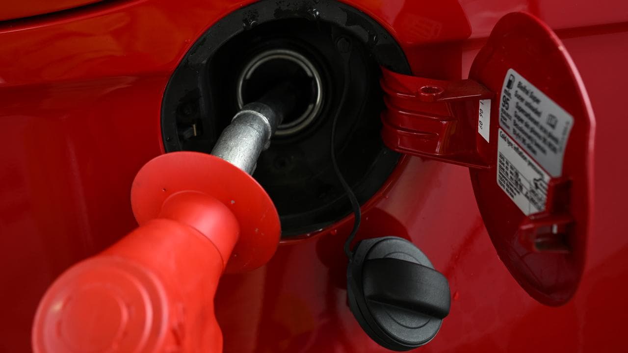 A fuel pump nozzle is used at a petrol station.