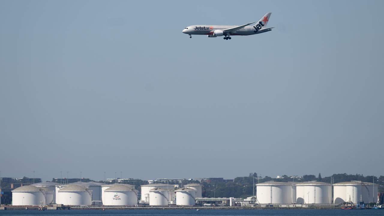 A plane flys past Vopak Terminal bulk liquid fuel storage facility