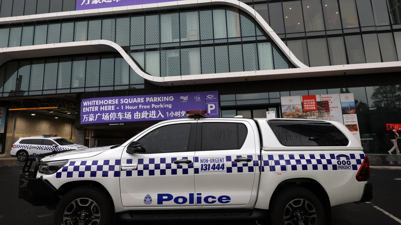 Police cars are seen outside the scene of a shooting in Box Hill