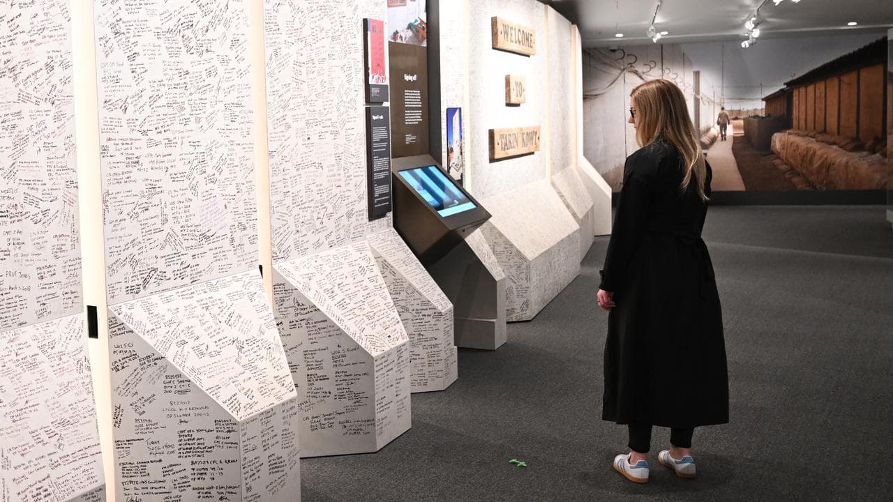 A visitor looks at a the Tarin Kowt Wall display