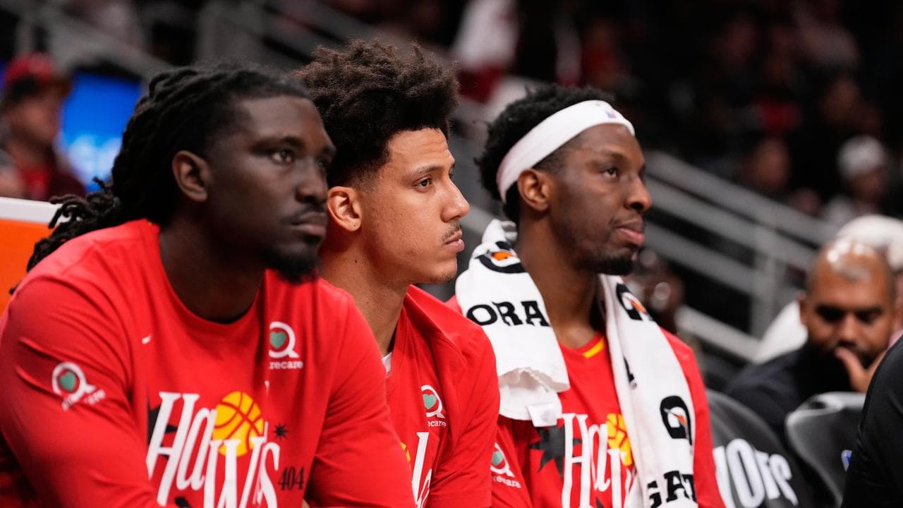Atlanta Hawks players watch from the sidelines
