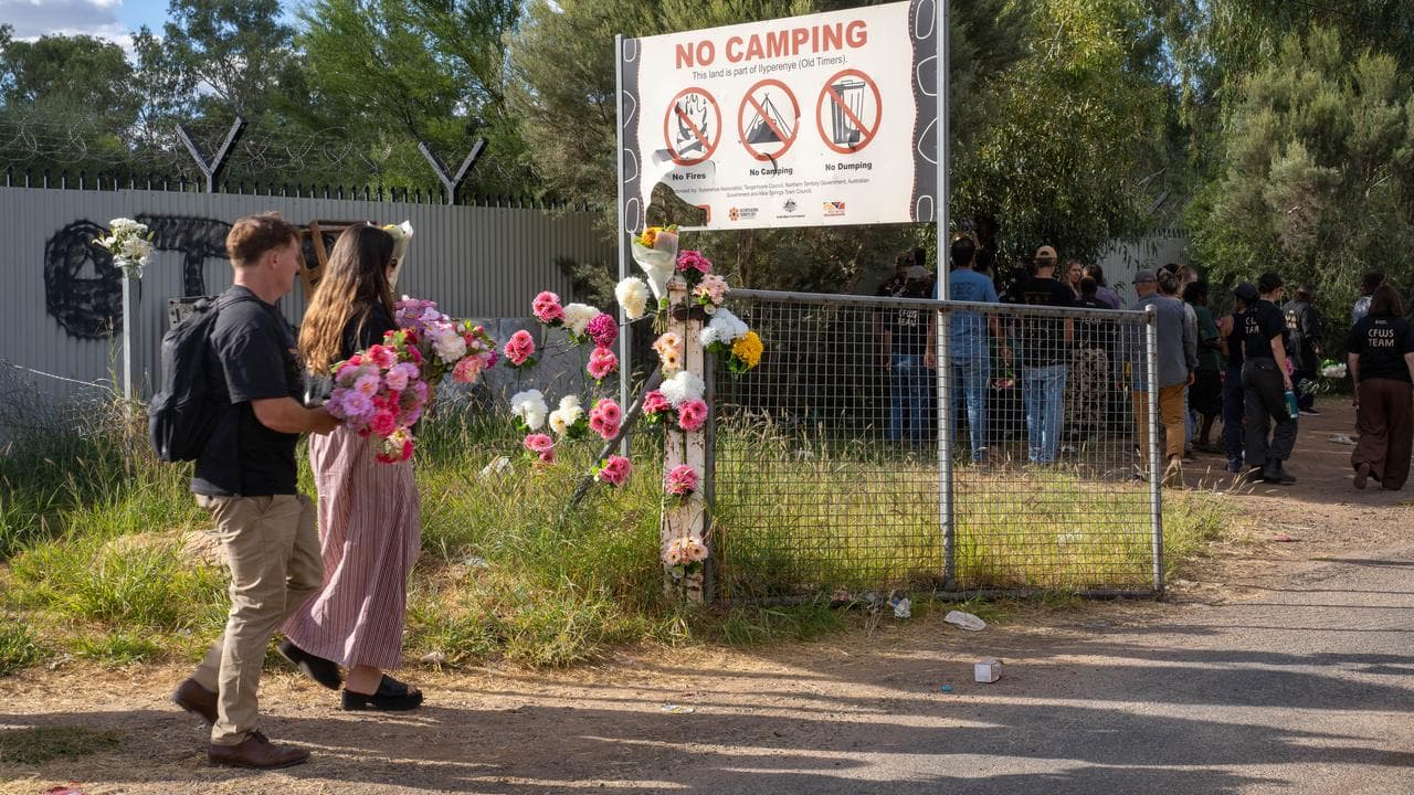 Alice Springs residents place flowers at a town camp