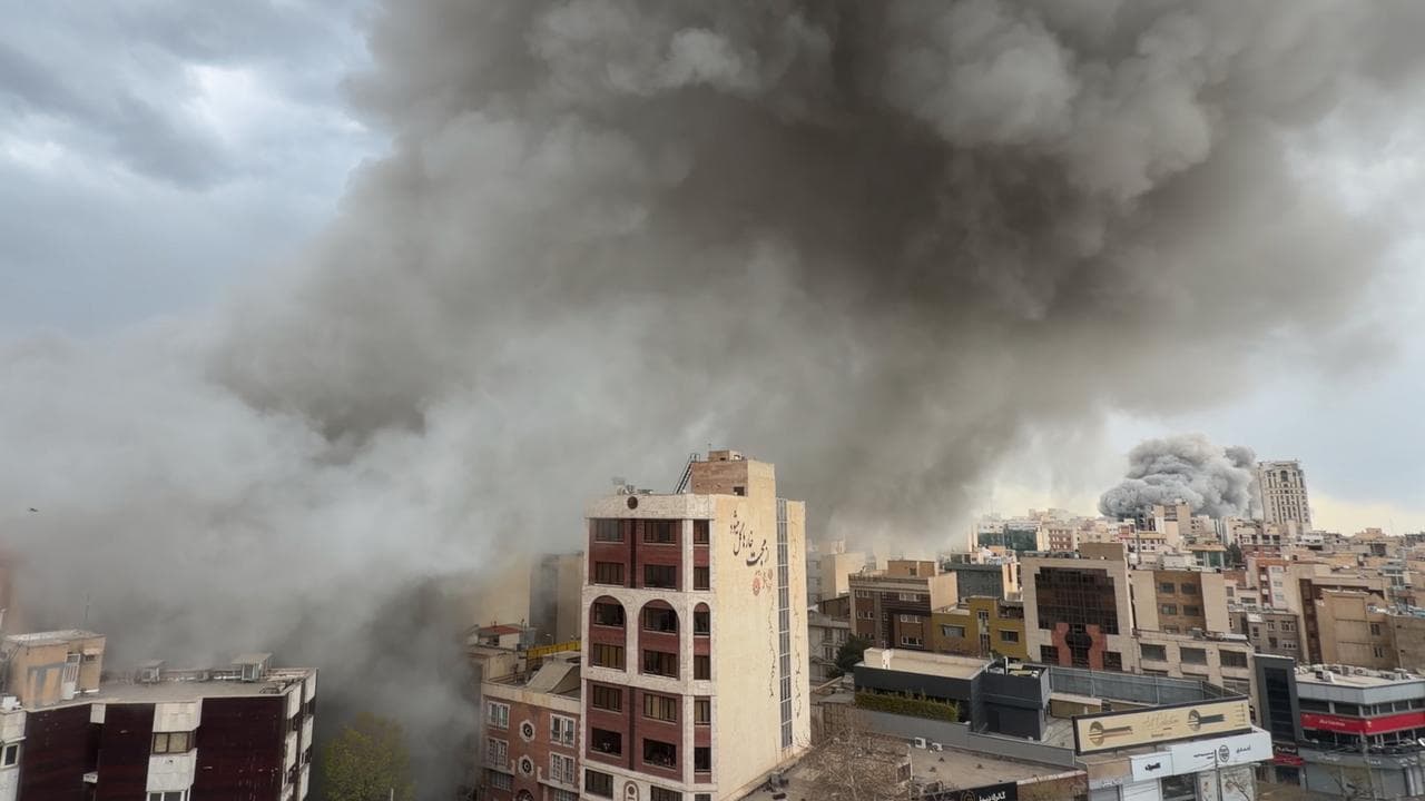 Plumes of smoke from two simultaneous strikes rise over Tehran, Iran