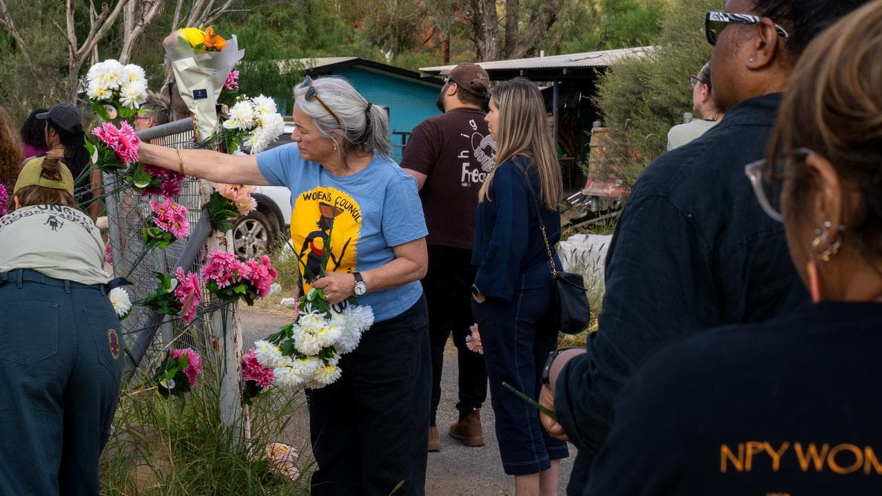 Alice Springs residents place flowers on gates and fences