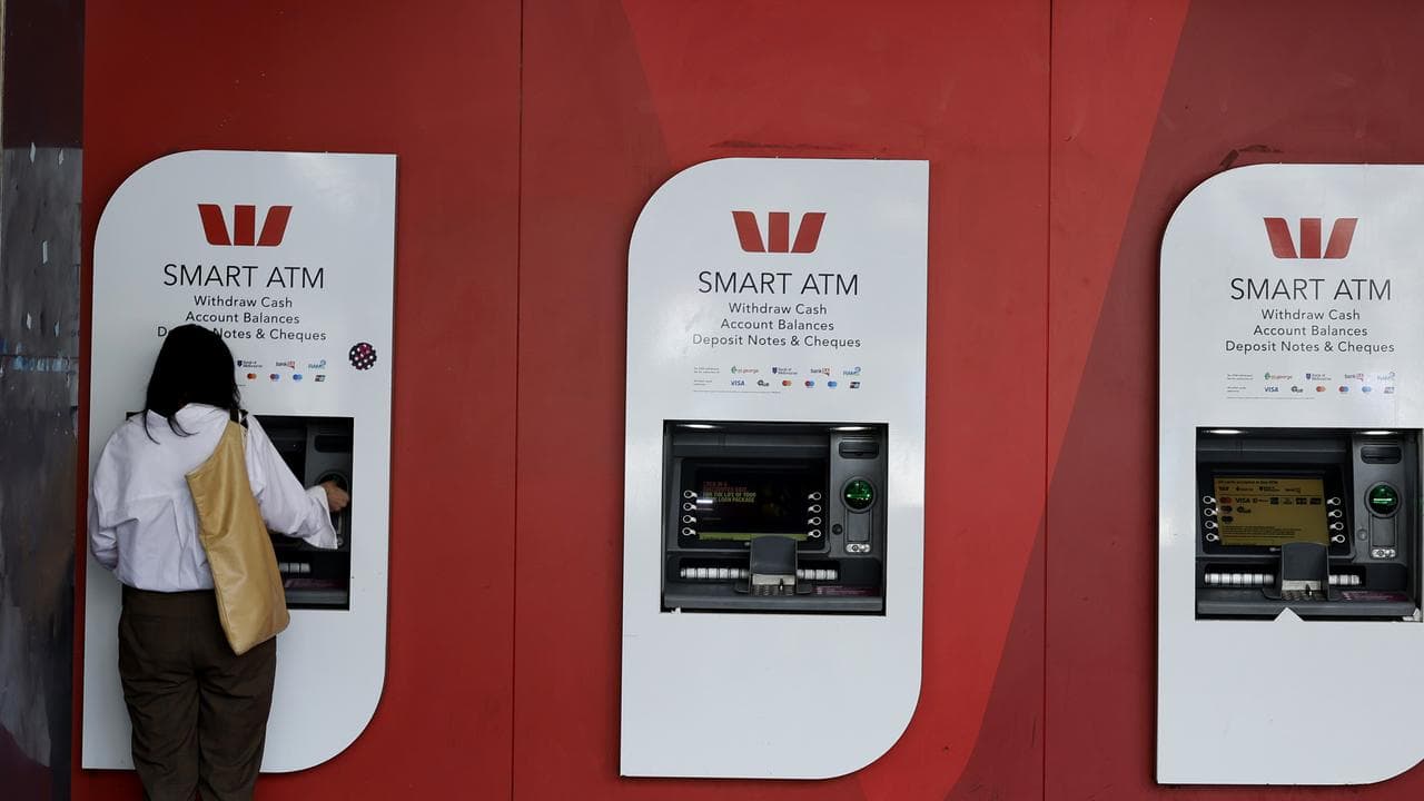 A person is seen on an ATM at a bank branch in Melbourne