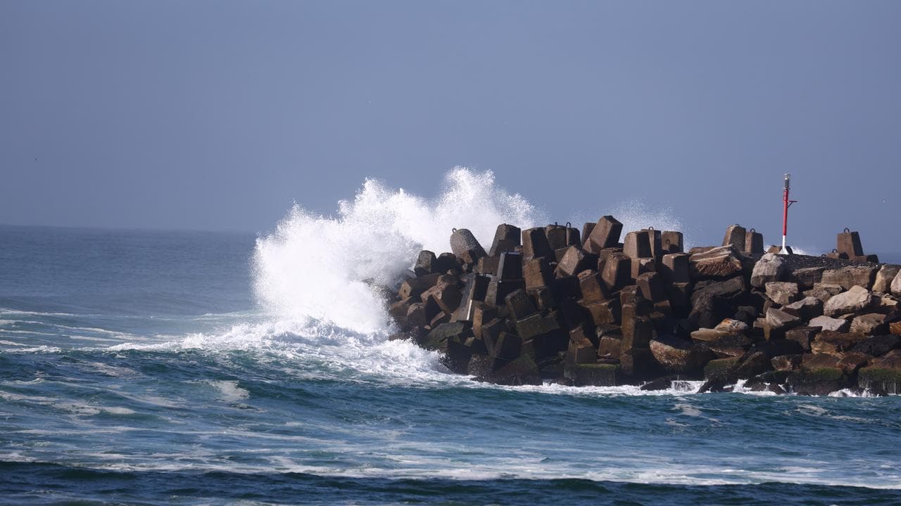 A wave crashes into the South Ballina break wall in NSW