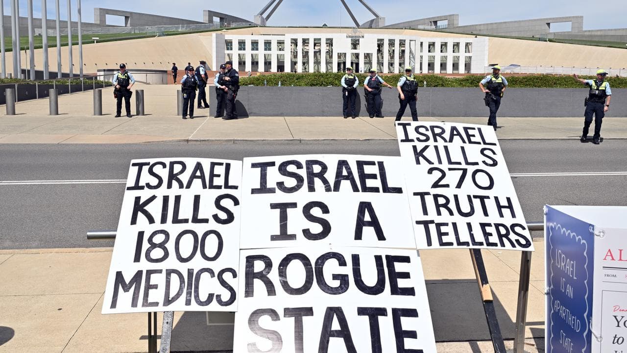 Police at a rally to protest the visit of Israel’s President