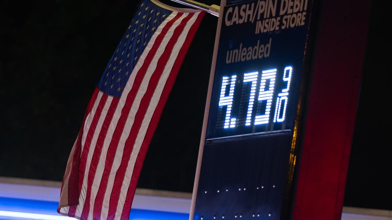 An American flag flies near a fuel price sign in Portland, Oregon