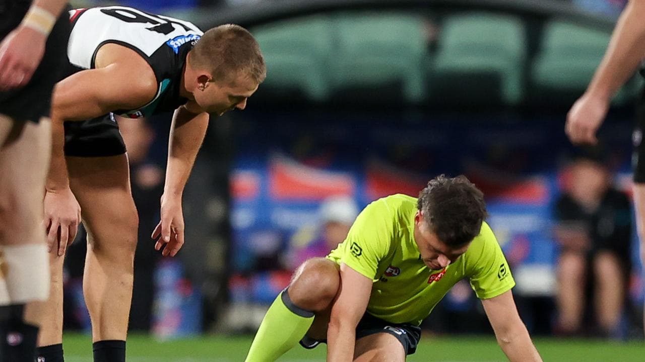 Port Adelaide's Ollie Wines checks on umpire Daniel Johanson.