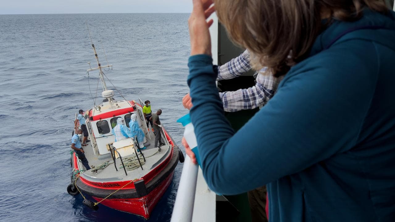Passengers on MV Hondius watch epidemiologists board the boat