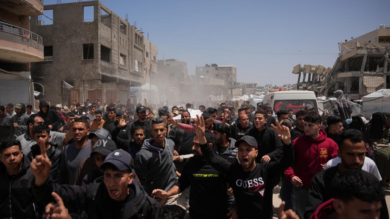 Palestinians pray beside the bodies of men killed in an Israeli strike