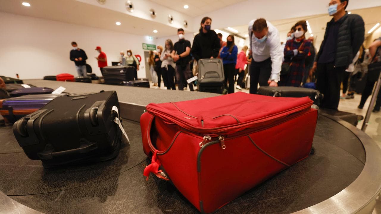 Airport arrivals collect luggage at Hobart Airport.