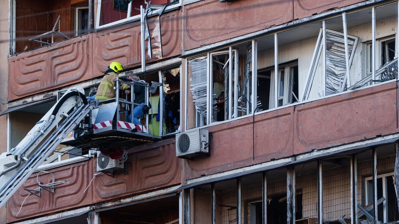A woman is moved from a balcony after a Russian strike in Kyiv