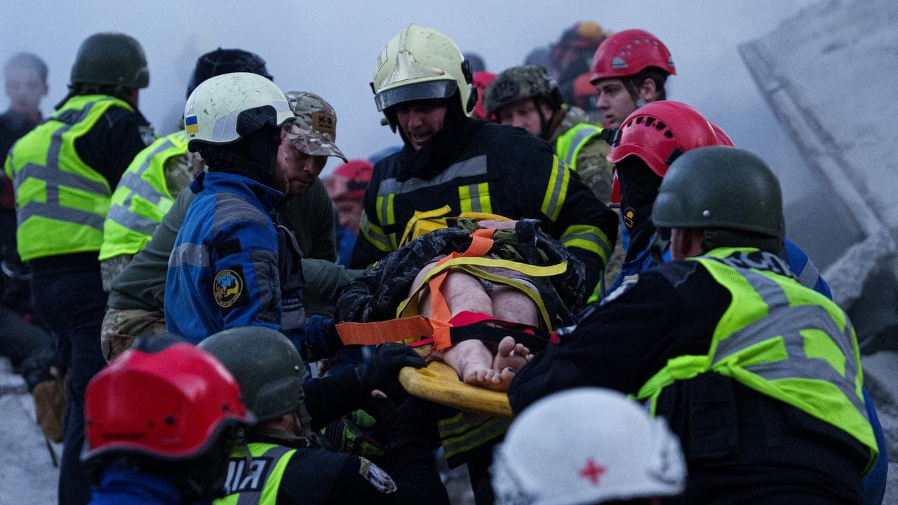 Rescue workers carry an injured woman after a Russian strike in Kyiv