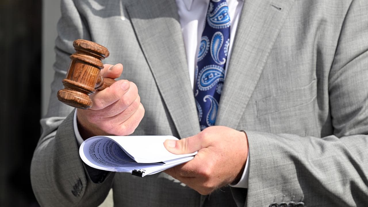 A gavel is held by an auctioneer