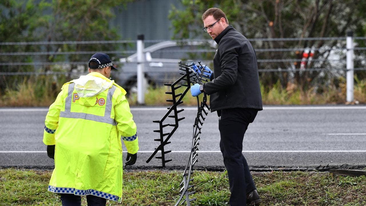 Police inspect the tyre-deflating stinger at the scene (file)