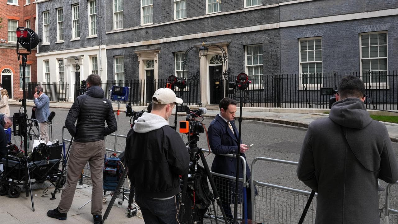 Journalists wait opposite 10 Downing Street in London