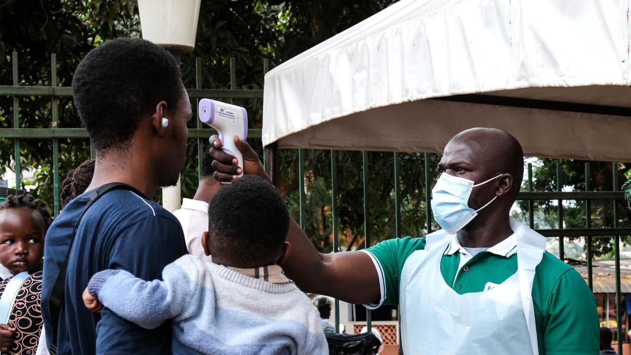 A health official checks temperatures in Kampala