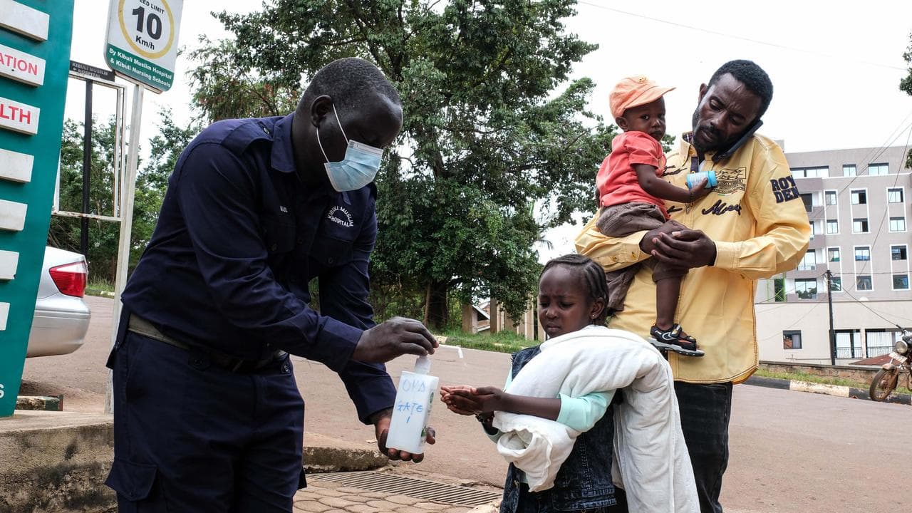 A girl sanitises her hands outside Kibuli Muslim Hospital in Uganda