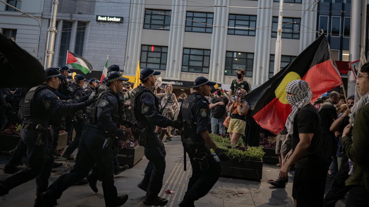 Police advance on protesters opposed to an Israeli President's visit.