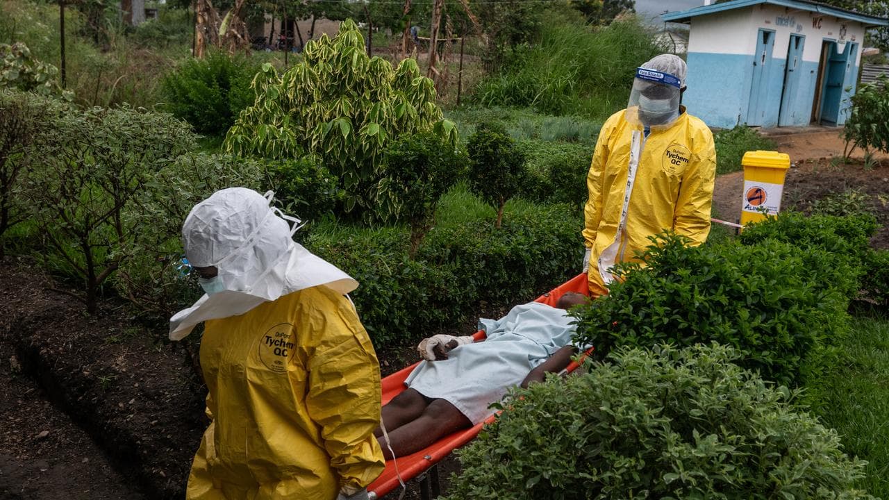 Staff carry an Ebola patient to a treatment center in Rwampara, Congo