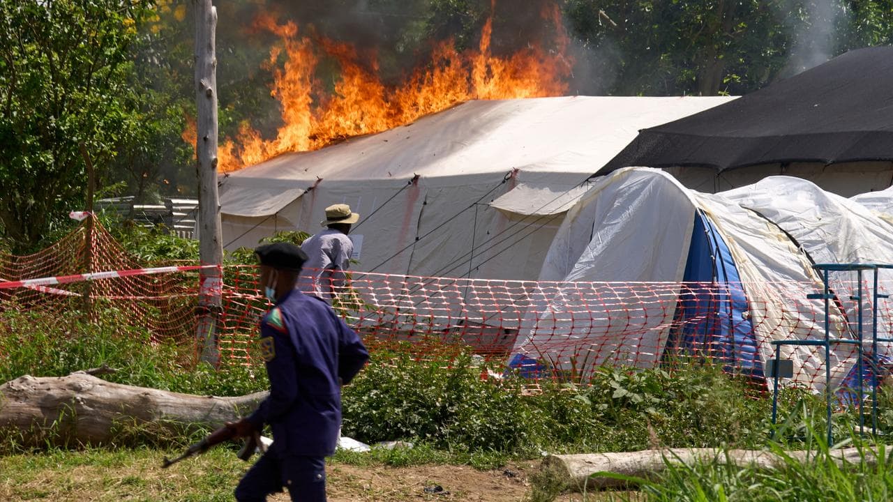 A security guard in front of a burning Ebola treatment centre in Congo