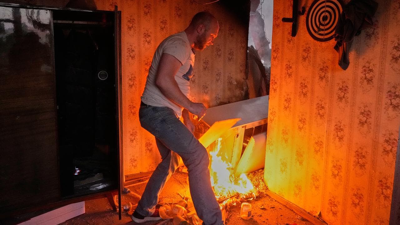 A man tries to put out a fire in his Kyiv apartment