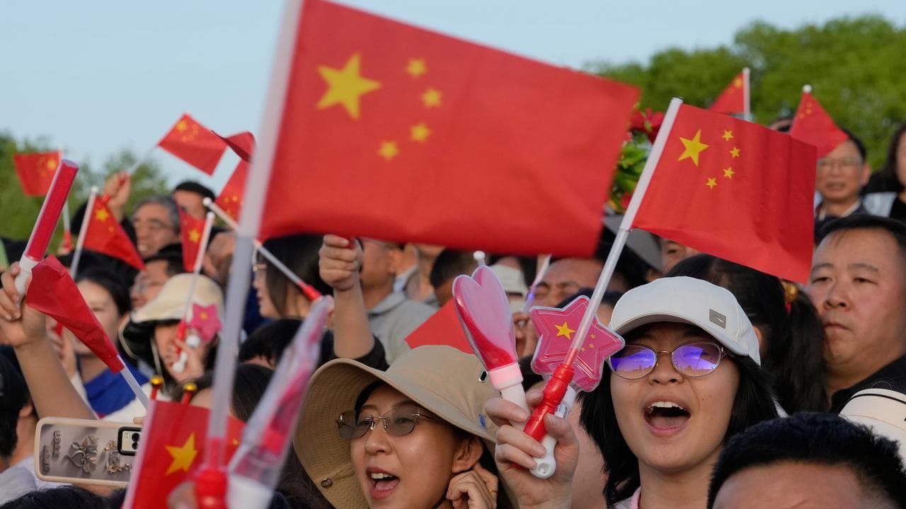 Crowds waving Chinese flags
