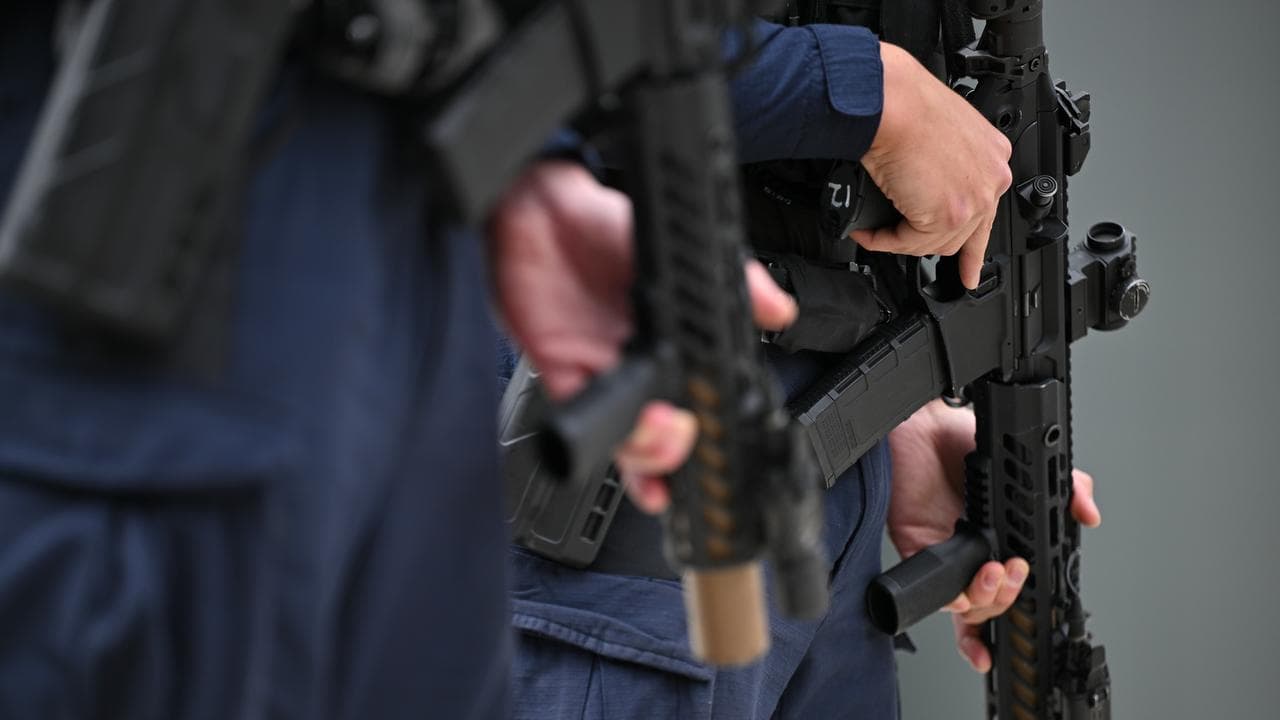 Police carrying long arm weapons