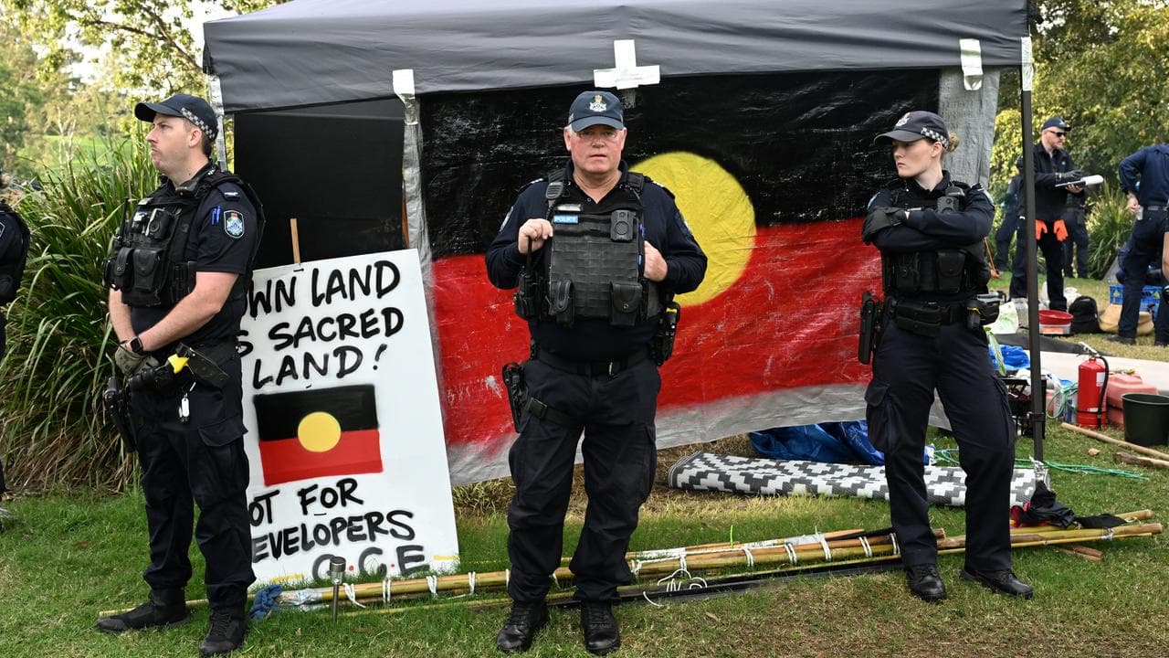 Police guard a tent embassy in a park