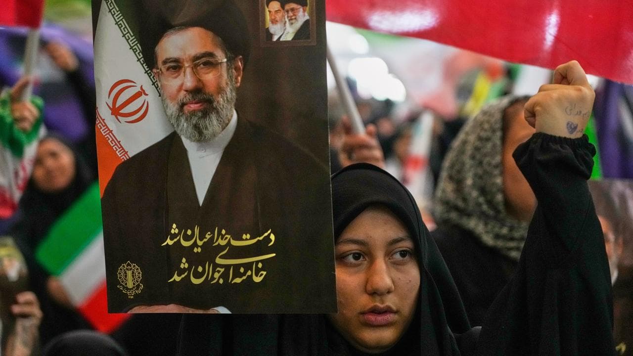 An Iranian woman holds a portrait of Supreme Leader Mojtaba Khamenei