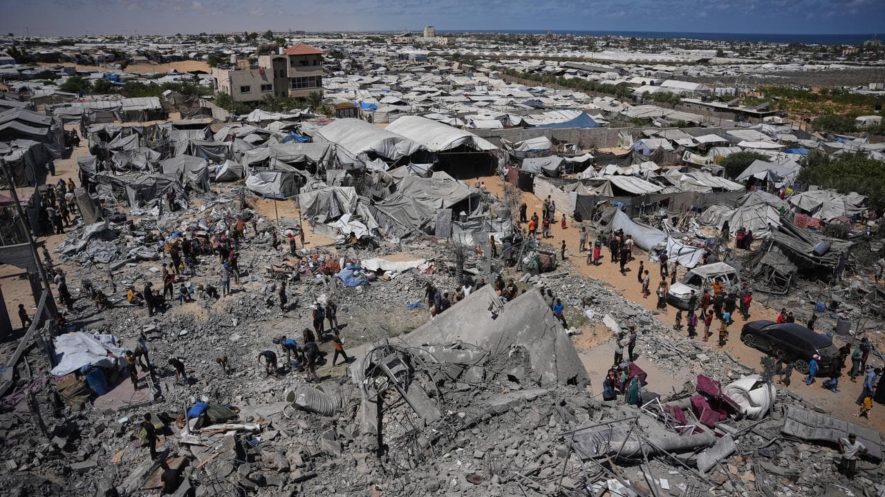 Palestinians inspect the rubble of a building