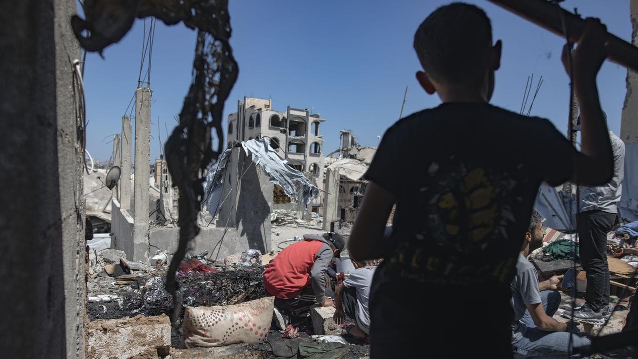 Palestinians inspect the site of an Israeli airstrike