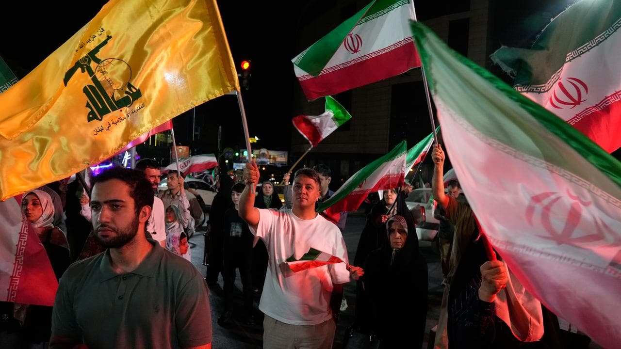 A man holds up a flag of Lebanon's Hezbollah group in Tehran, Iran