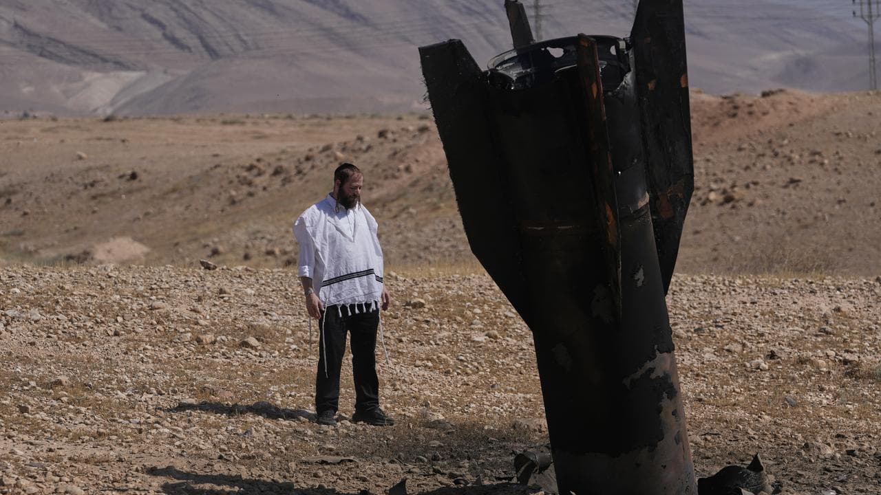 A man looks at the wreckage of an Iranian missile in the West Bank