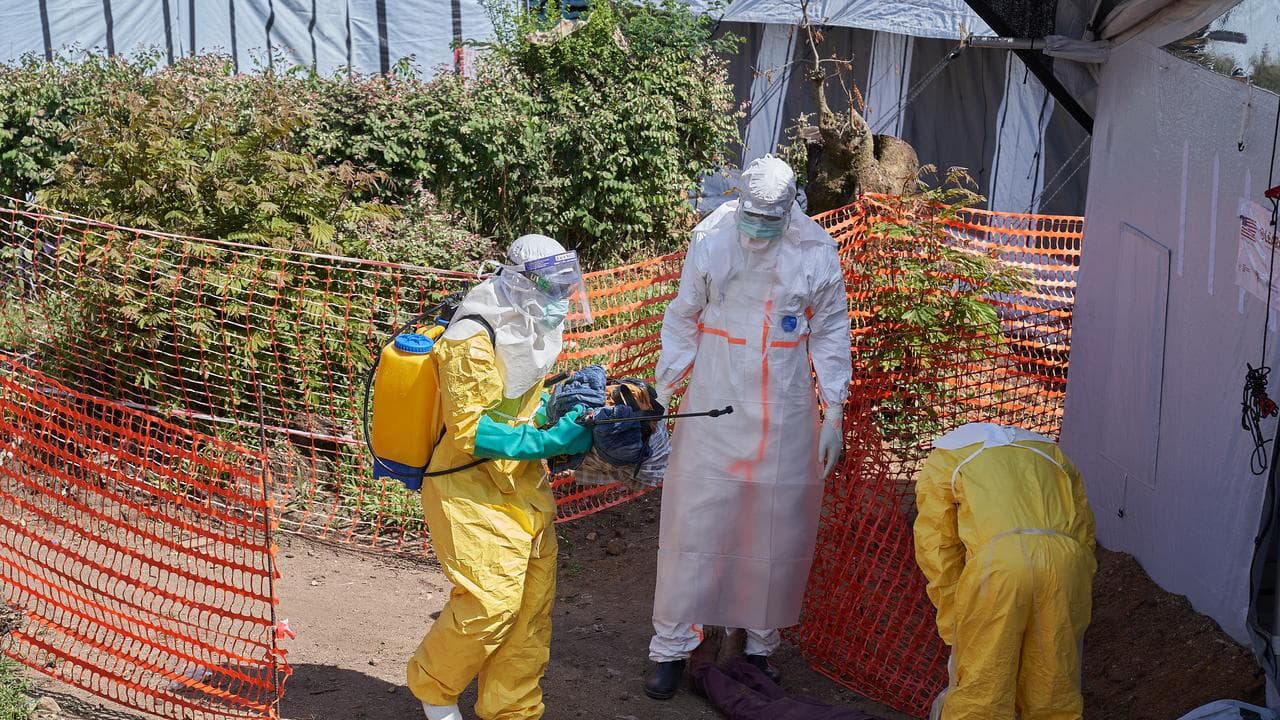 Medical staff disinfect the body of a man infected with Ebola