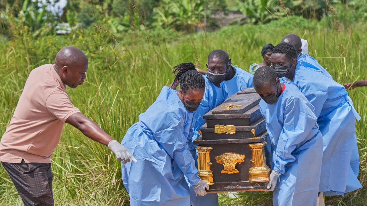 The coffin of an Ebola victim is carried to a gravesite in Rwanpara
