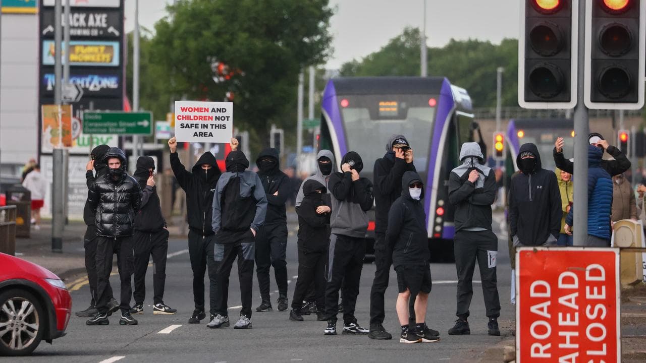 A crowd of protesters gathers after a stabbing incident in Belfast