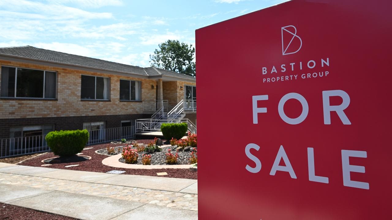 A ‘For Sale’ sign is seen near a house