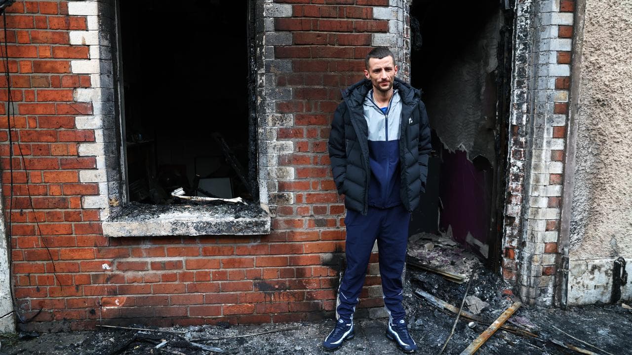 A resident outside his burnt-out house after rioting in east Belfast
