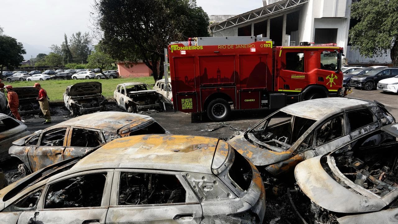 Burned vehicles fill a car dealership