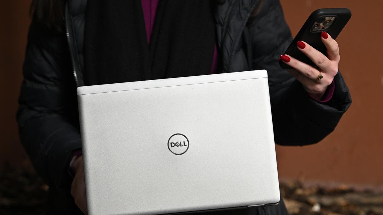 A person holding a mobile phone and laptop (file image)